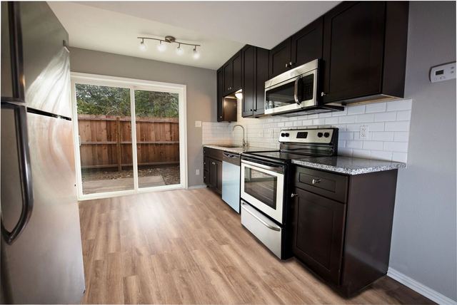 Kitchen with espresso cabinets, stainless appliances and sliding patio door