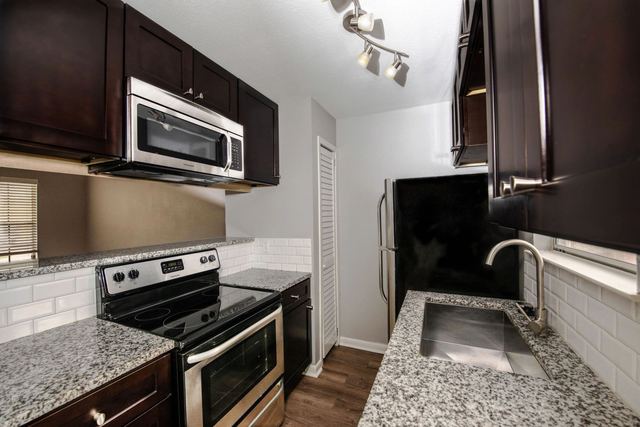 Kitchen with granite countertops and subway tile backsplash
